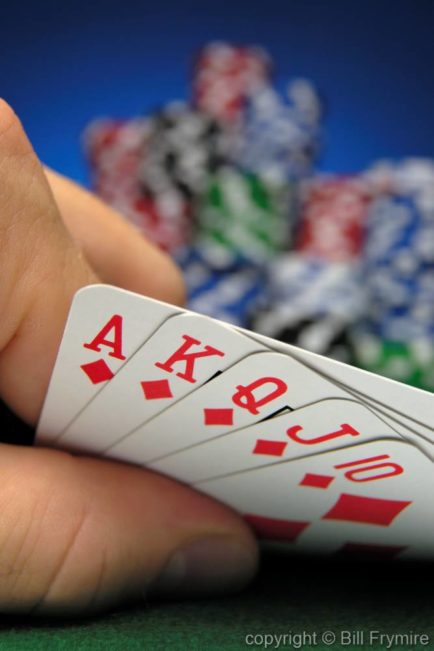 Royal flush in diamonds on poker table with poker chips in the background fold hold