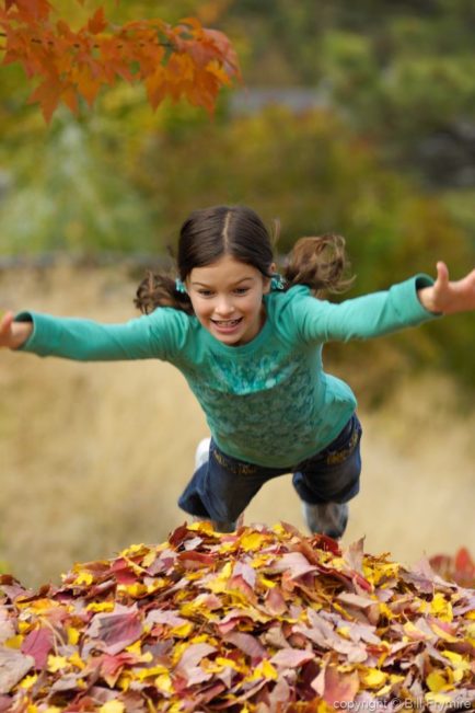 Girl jumping in the leaves